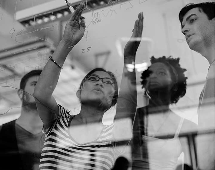 A group of diverse individuals gazing attentively at a large window, engaged in conversation